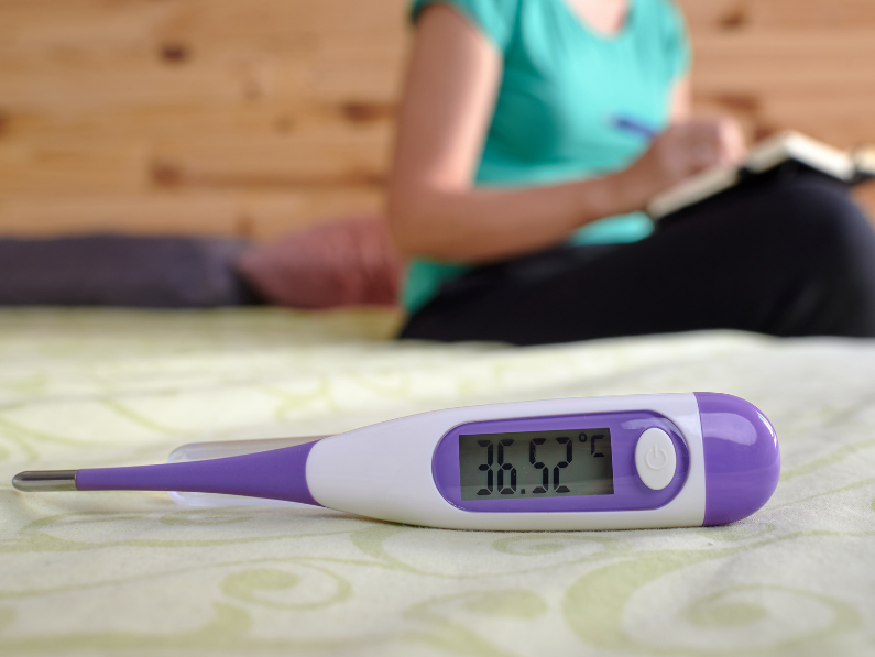 woman recording her basal body temperature
