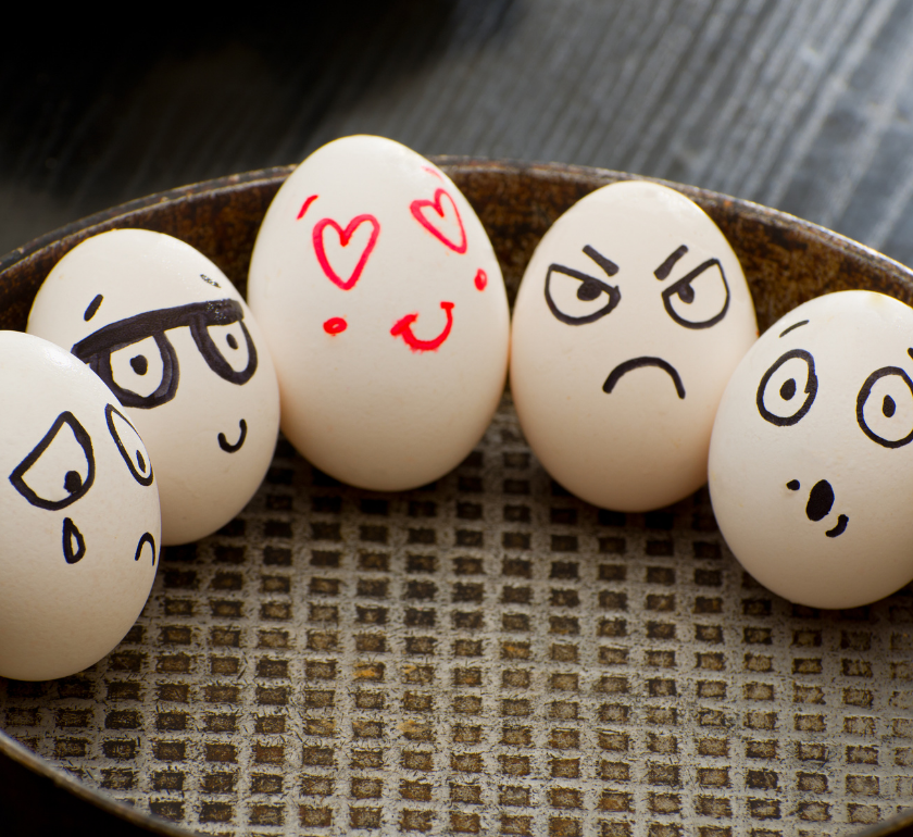 eggs in a basket with different faces drawn on them