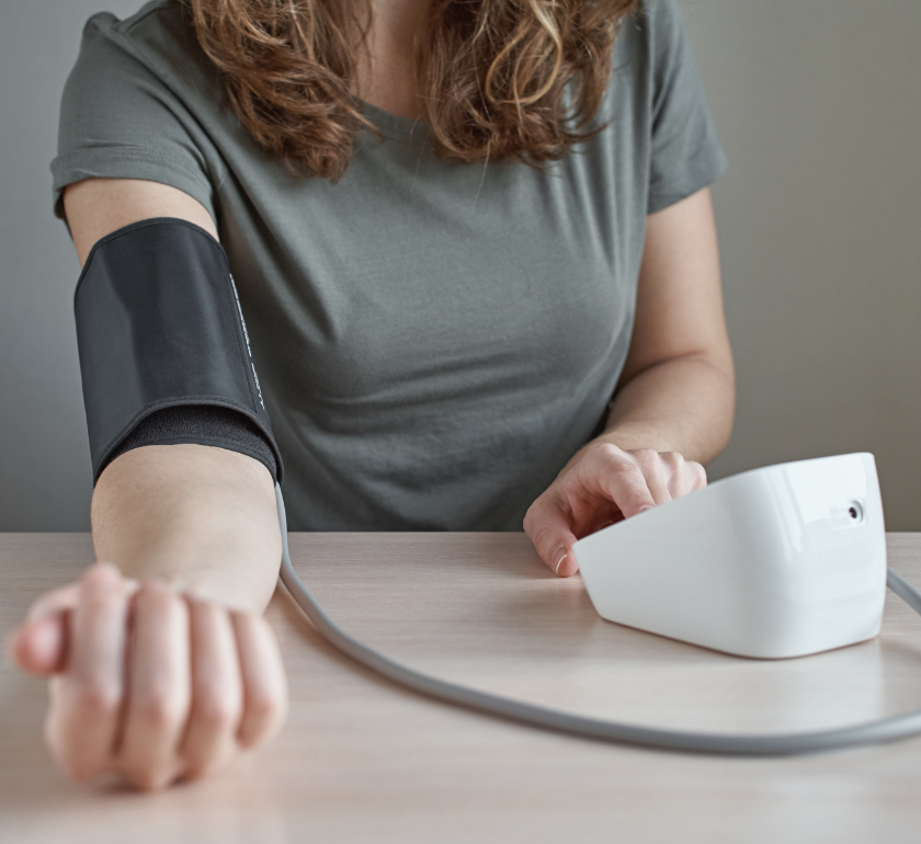 woman taking blood pressure reading using a digital blood pressure machine with an arm cuff