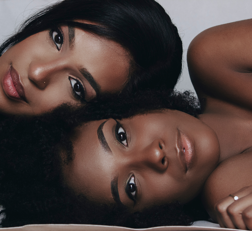 two african american women with their heads laying on top of each other facing forward