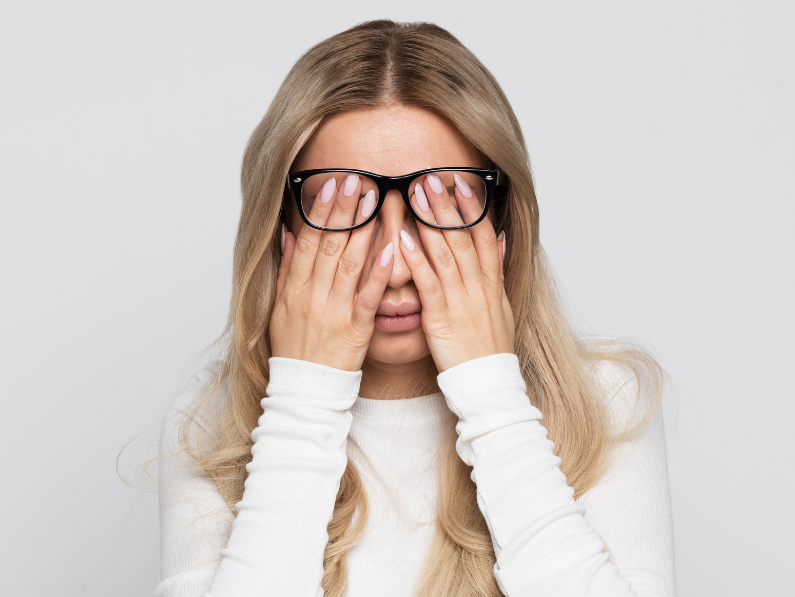 woman covering her eyes underneath glasses as she struggles with chronic fatigue