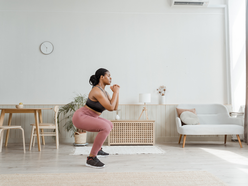 woman on her fitness journey doing squats in her living room